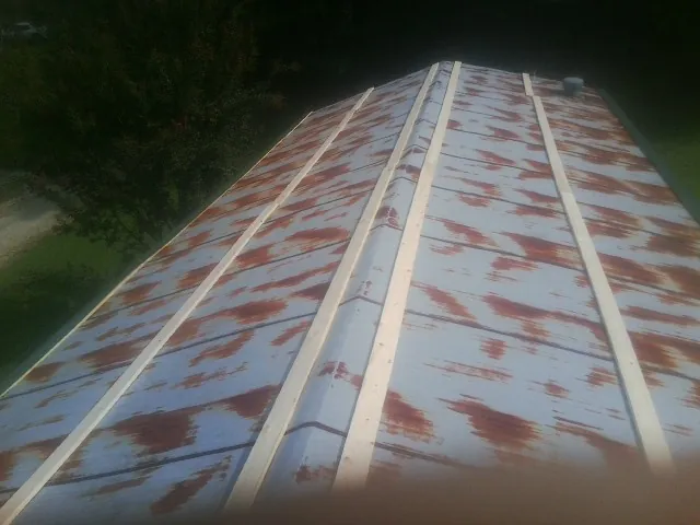 Rusted metal roof panels with new wood purlins before replacement — Storm Damage Roof Repair in Ulysses by Roofing Brothers
